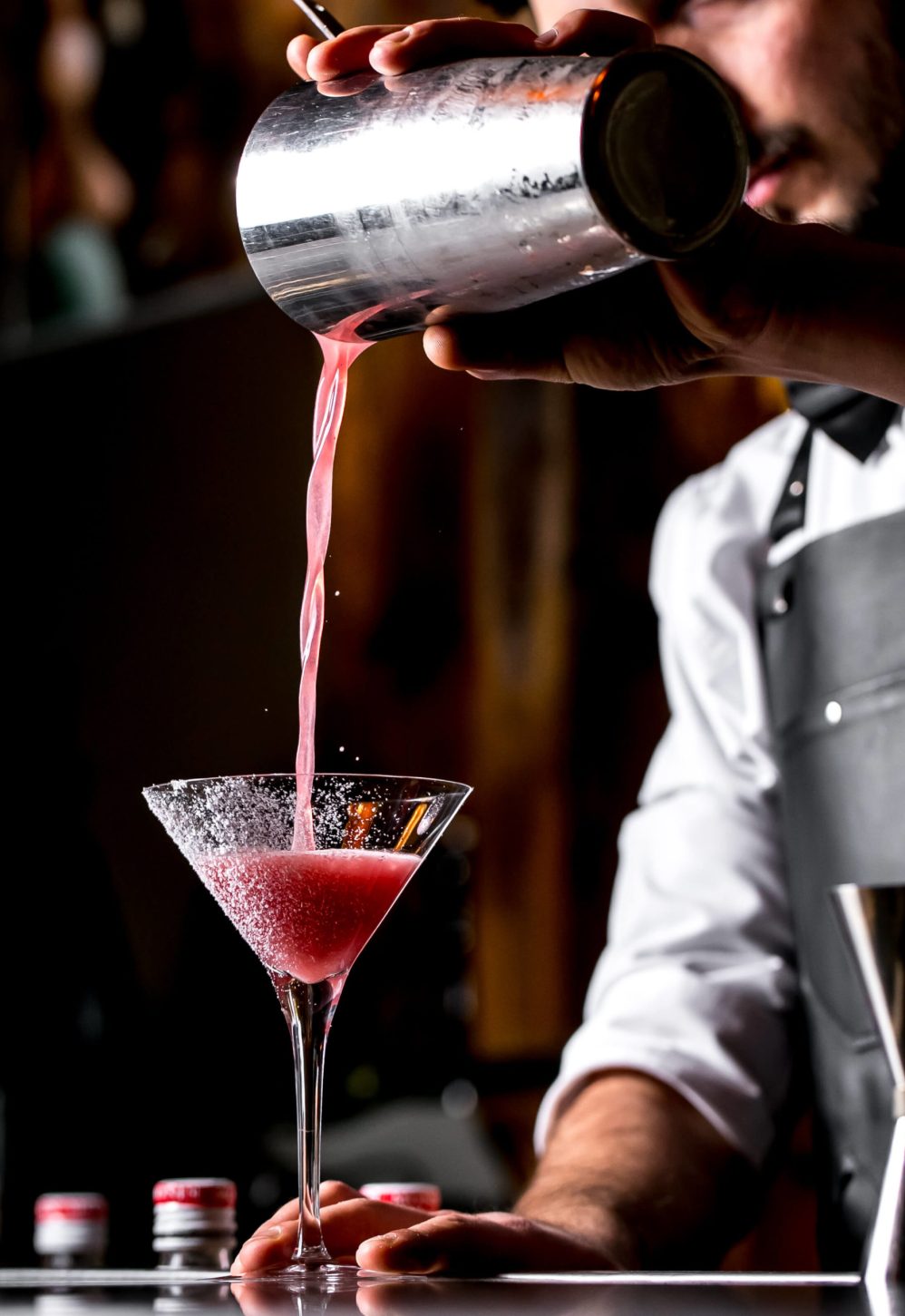 bar-tender-pours-cocktail-from-cocktail-shaker-into-martini-glass (1)